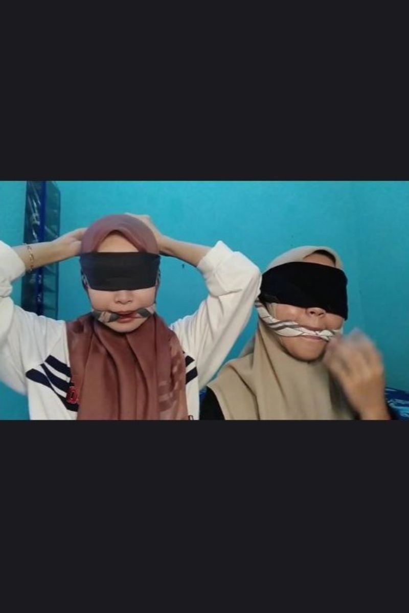 2 young girls use handkerchiefs as masks, cleave gags and blindfolds